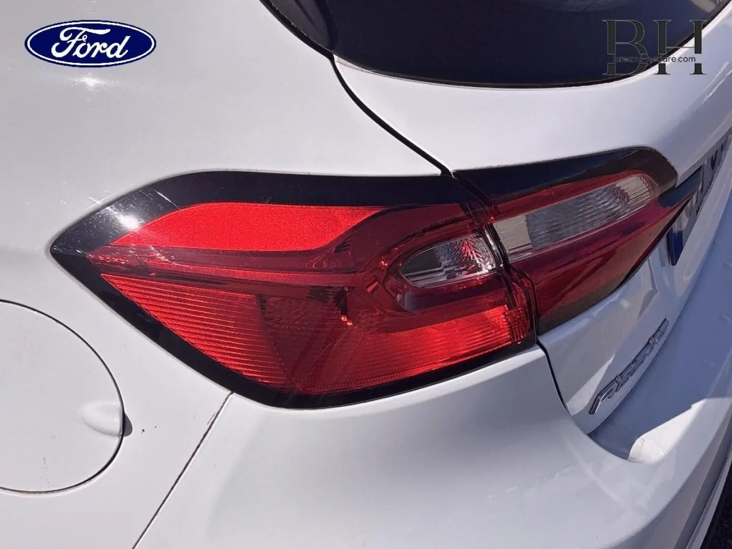 Gros plan sur le feu arrière gauche d'une Ford Fiesta 2023 blanc glacier, mettant en valeur la carrosserie et les lignes arrière.