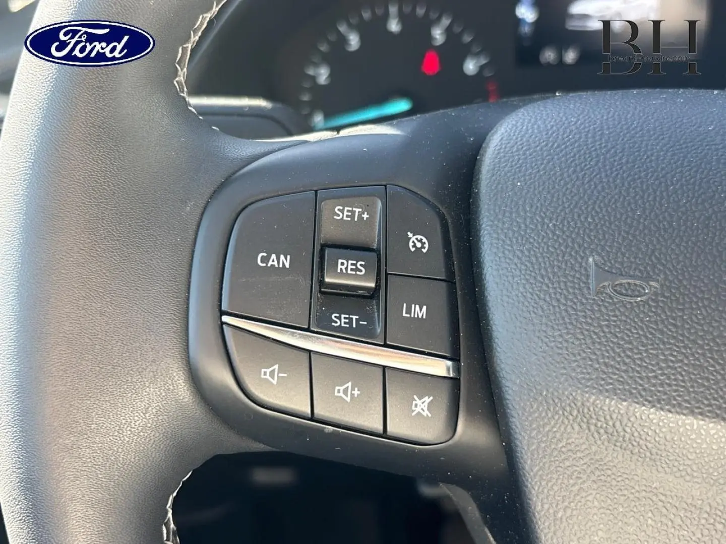 Gros plan sur les commandes de régulateur et volume au volant cuir de la Ford Fiesta Titanium Business 2023.