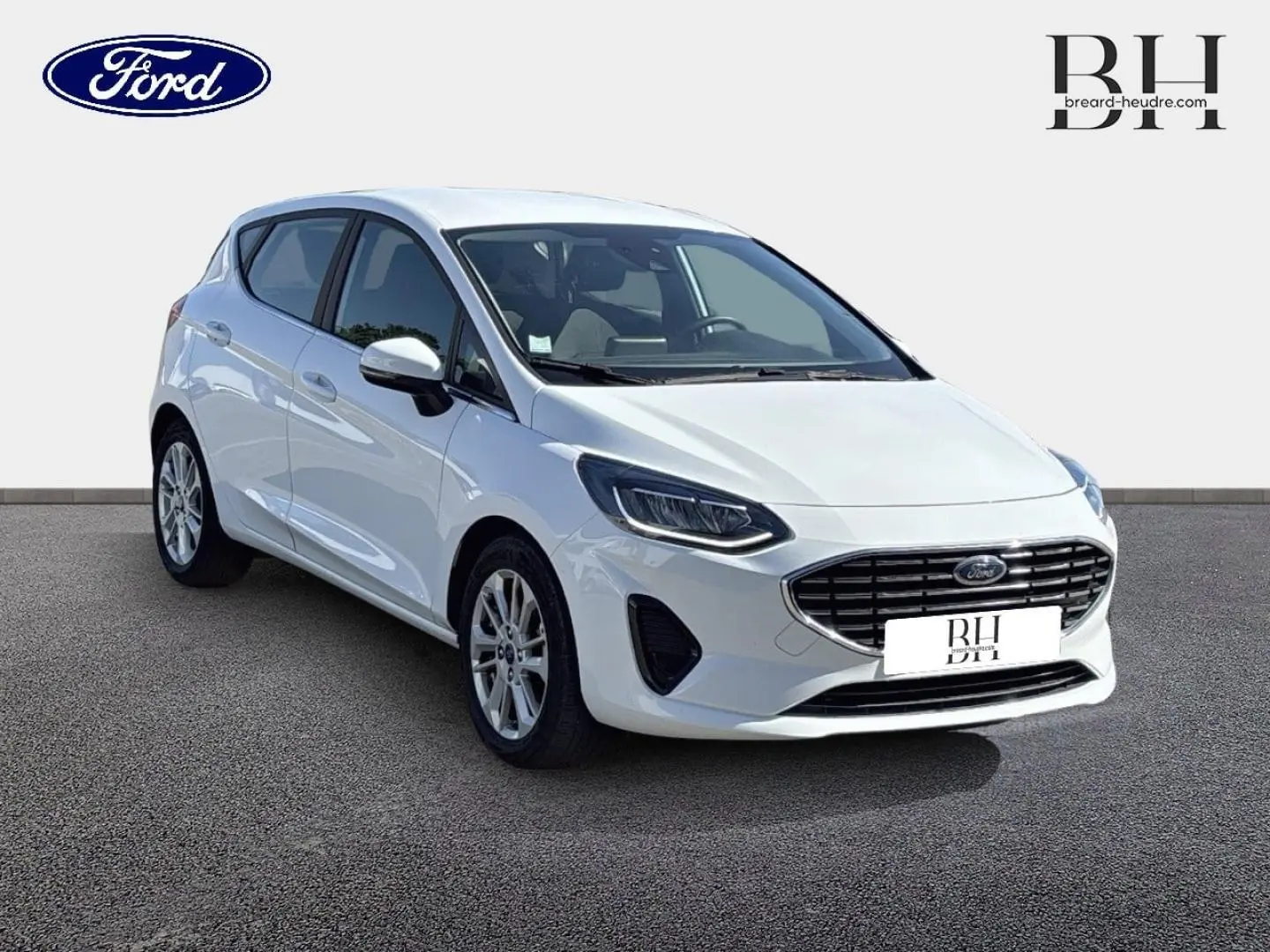 Ford Fiesta blanc glacier vue 3/4 avant droit avec calandre chromée et jantes alu visibles.