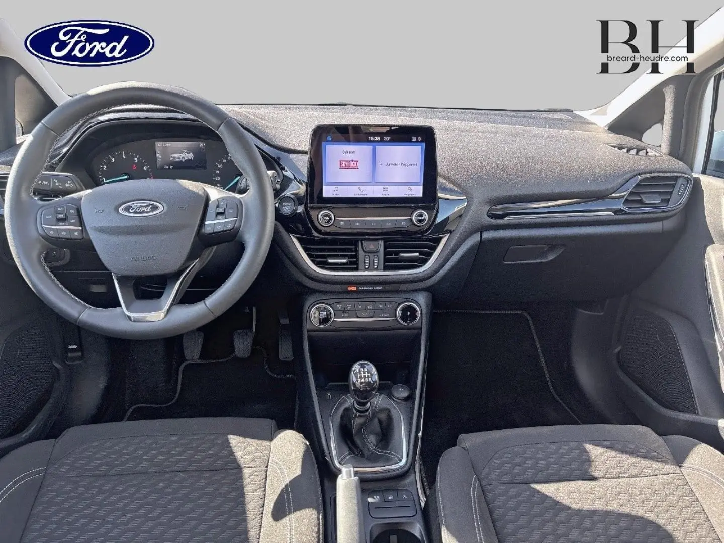 Vue intérieure avant de la Ford Fiesta 2023, montrant le volant cuir, la console centrale avec écran tactile et la boîte manuelle.