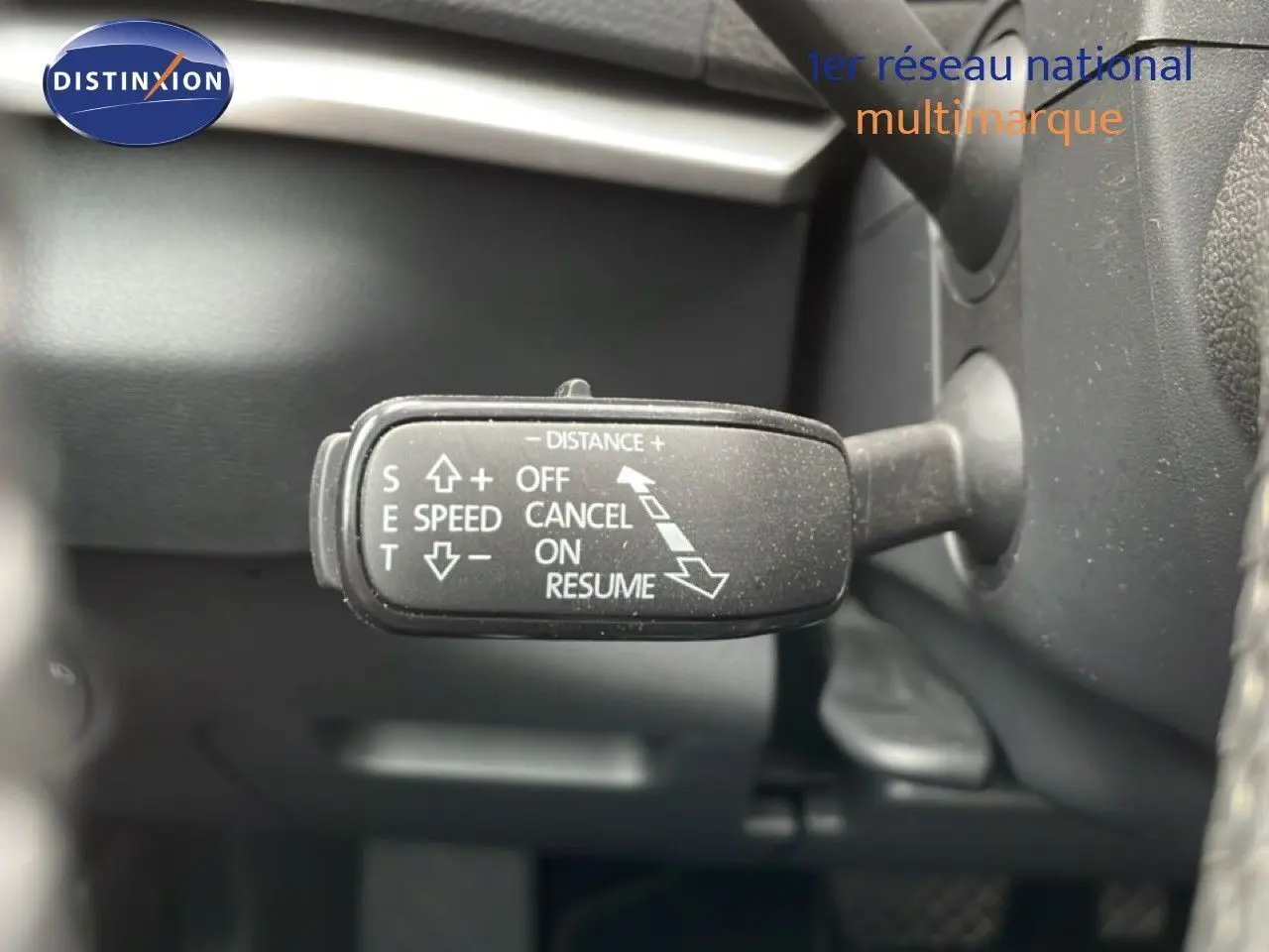 Gros plan sur le levier de commande du régulateur de vitesse dans l’habitacle noir du Skoda Karoq blanc glacier.