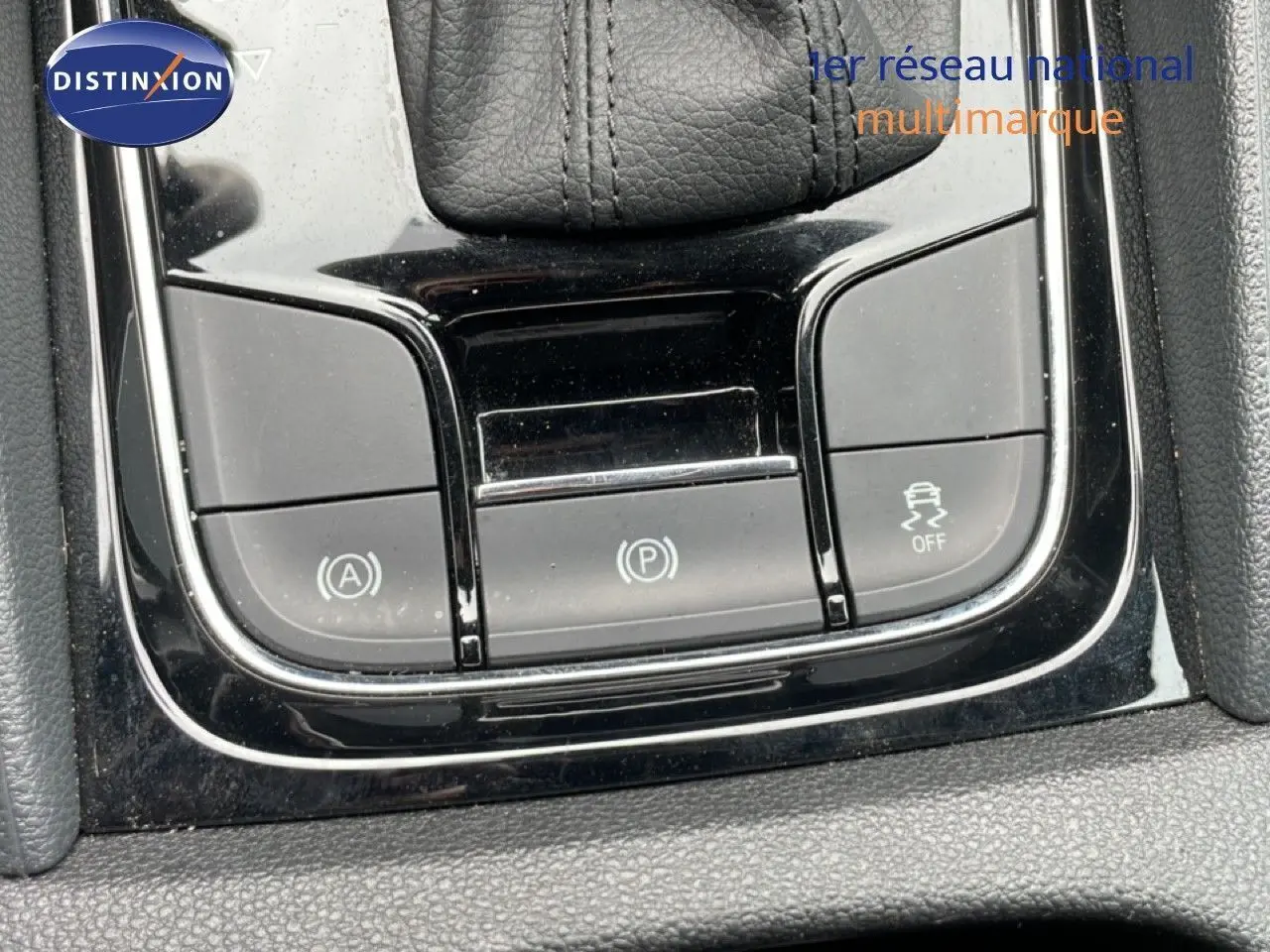 Gros plan sur les commandes de la console centrale noire du Skoda Karoq 1.5 TSI 150 DSG7, boutons de frein à main et aides à la conduite.