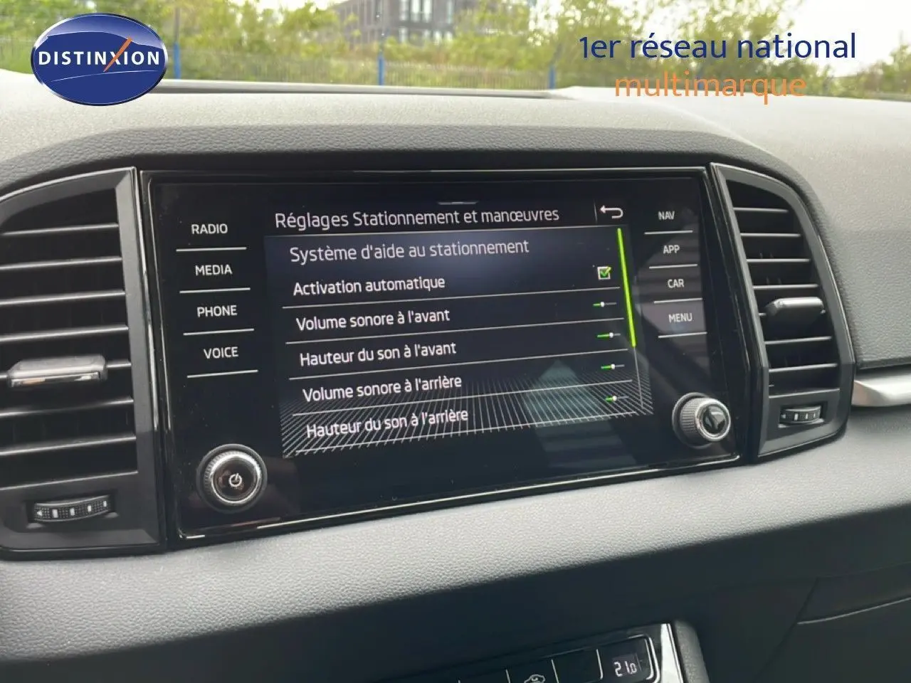 Écran tactile central du tableau de bord du Skoda Karoq 2025 affichant les réglages d'aide au stationnement.
