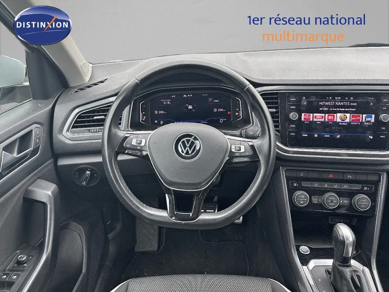 Vue intérieure du tableau de bord et volant noir du Volkswagen T-Roc 2021 avec écran tactile et commandes au volant.