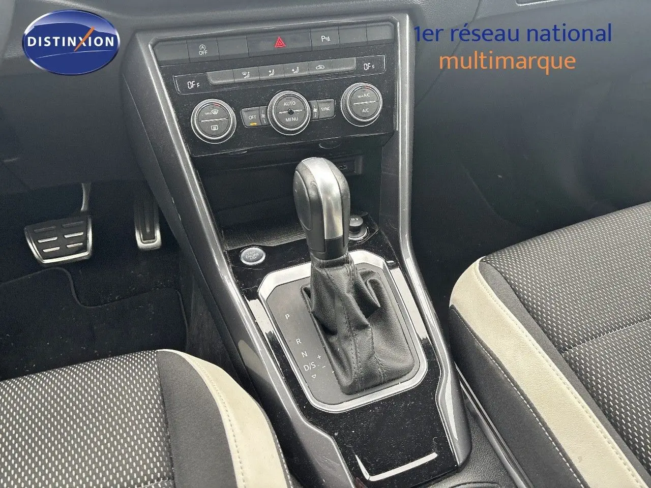 Vue rapprochée de la console centrale du Volkswagen T-Roc blanc argenté, mettant en valeur le levier de vitesse automatique.