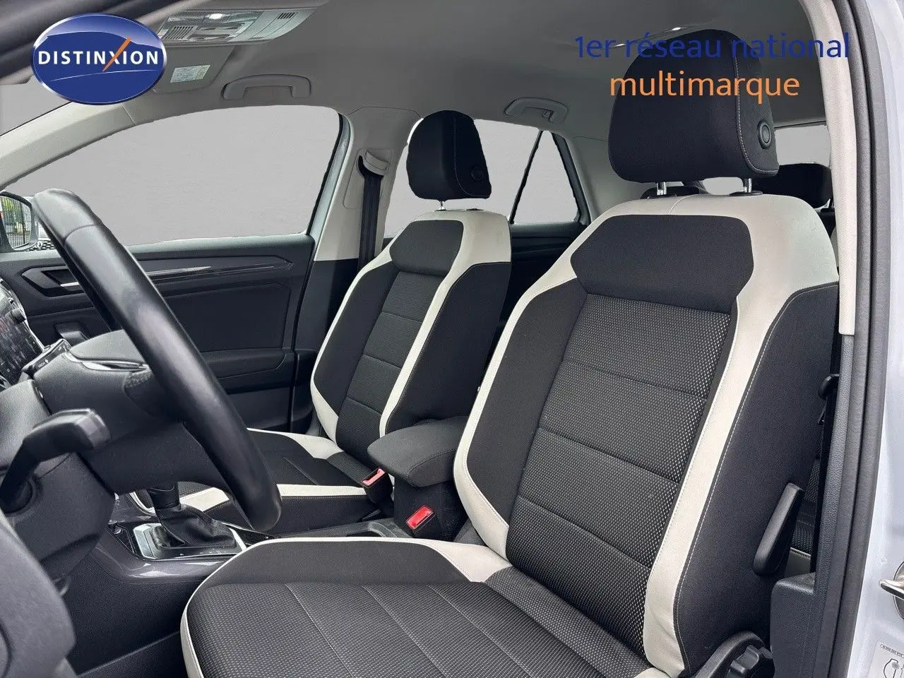 Intérieur du Volkswagen T-Roc 2021 en vue côté gauche, sièges tissu noir et blanc avec volant et console visibles.