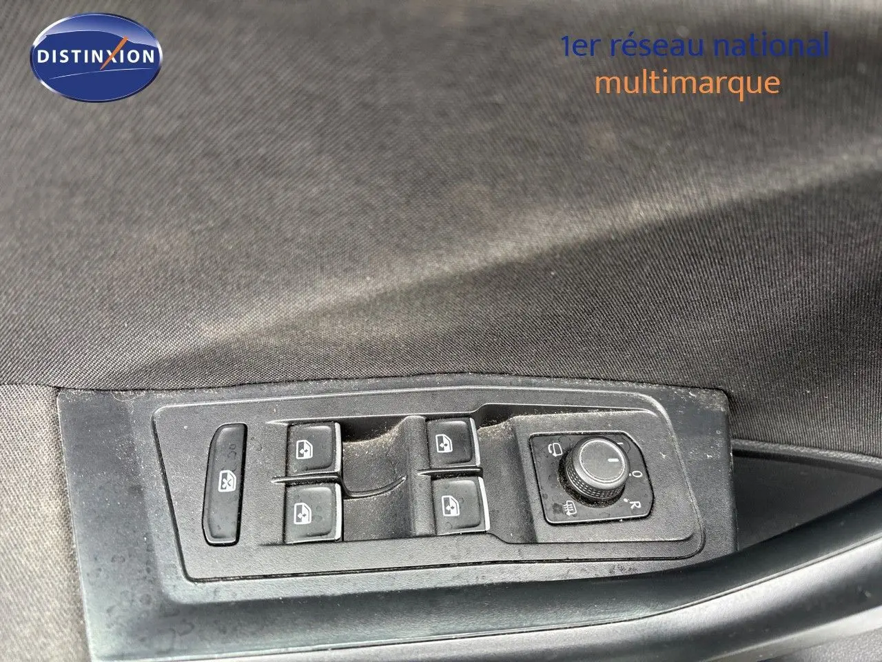 Panneau de commandes des vitres et rétroviseurs côté conducteur d'un Volkswagen T-Roc blanc argenté, intérieur tissu noir.