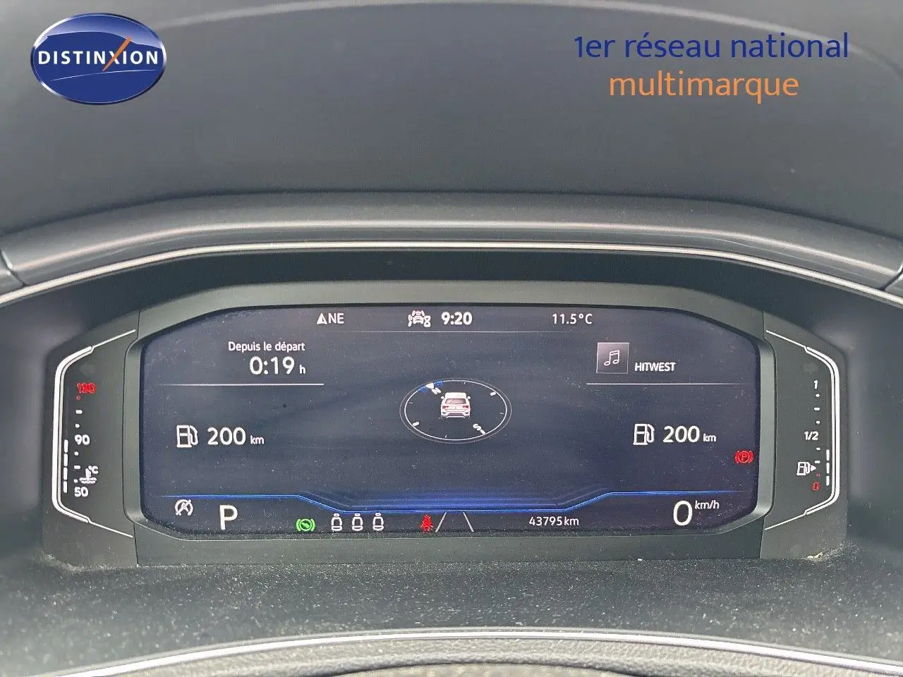 Tableau de bord numérique du Volkswagen T-Roc blanc, affichant la vitesse, autonomie et température extérieure.