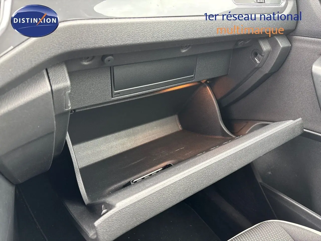 Vue 3/4 avant droit du Volkswagen T-Roc blanc argenté 2021 avec jantes alliage et feux LED allumés.