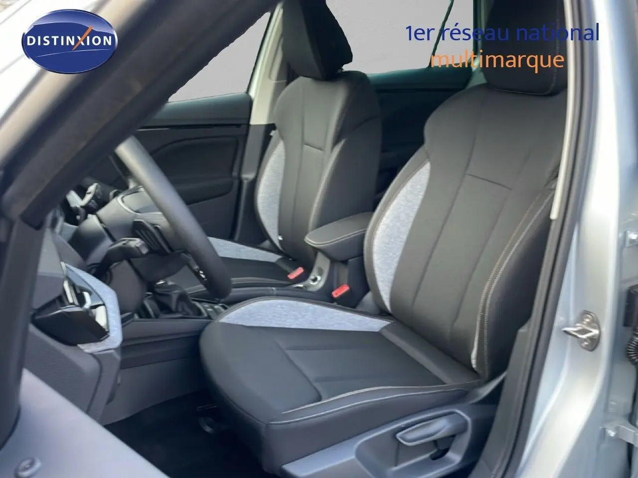 Vue intérieure côté conducteur du Skoda Kamiq gris argent, mettant en valeur les sièges bi-matière noirs et gris.