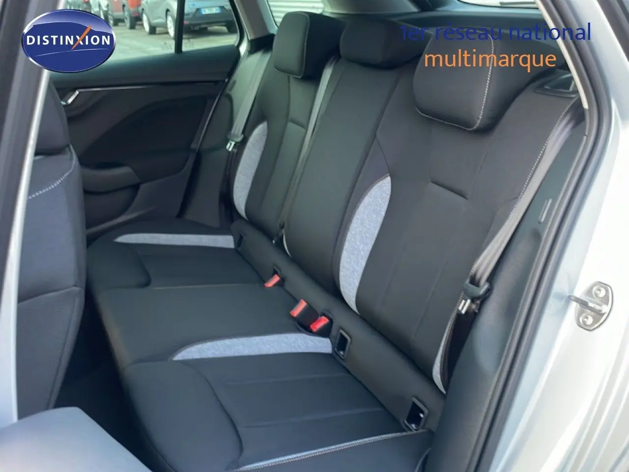 Vue intérieure montrant la banquette arrière en tissu noir et gris d'une Skoda Kamiq gris argent, porte arrière ouverte côté droit.