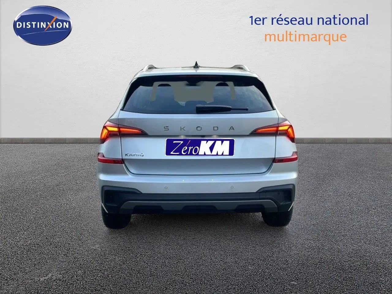 Vue arrière d'un Skoda Kamiq gris argent métallisé, avec feux LED allumés et plaque d'immatriculation Zéro KM.