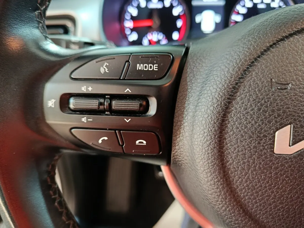 Gros plan sur la partie gauche du volant noir du KIA Stonic 2022 avec commandes audio et téléphone visibles.