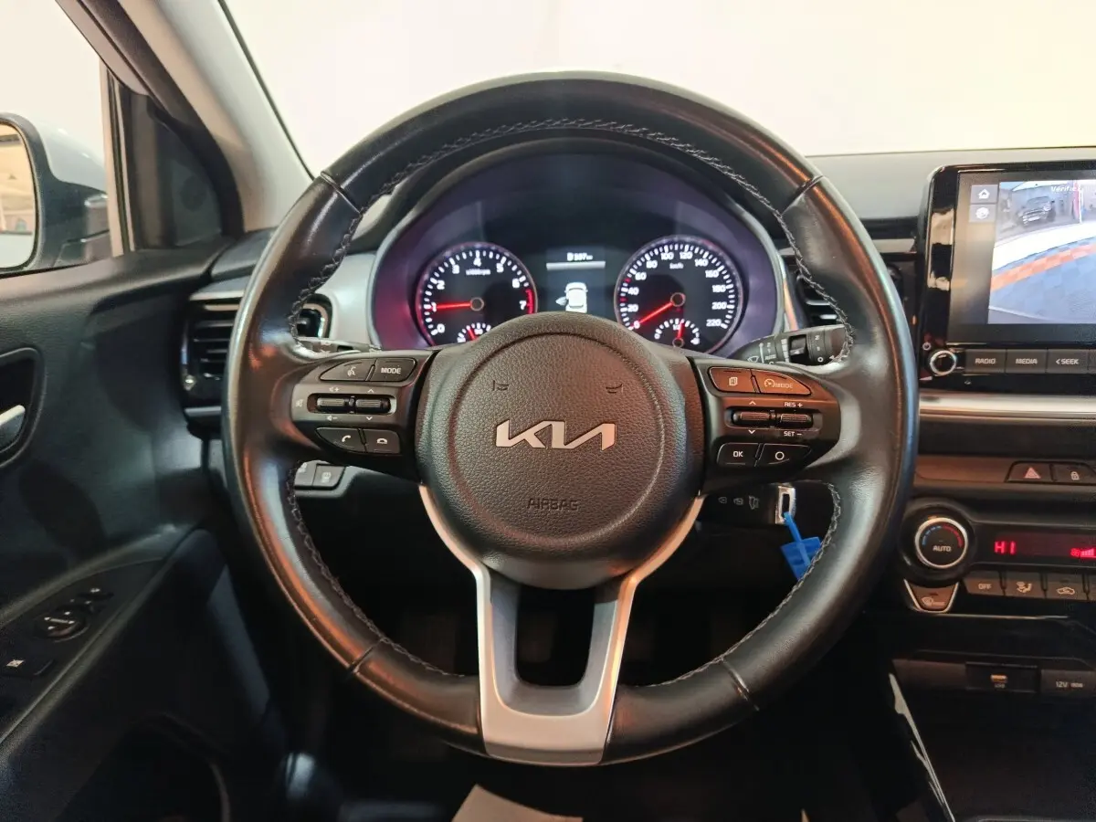 Vue intérieure centrée sur le volant noir du Kia Stonic 2022 avec tableau de bord et écran tactile visible à droite.