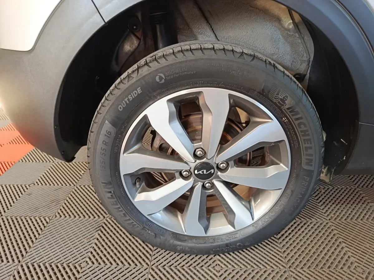 Gros plan sur la roue avant droite d’un KIA Stonic gris clair, avec jante alliage et pneu Michelin visible.