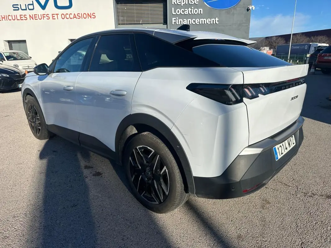 Vue 3/4 arrière droite du Peugeot 3008 Hybrid blanc avec jantes alliage noires de 19 pouces, vitres teintées et feux arrière LED.