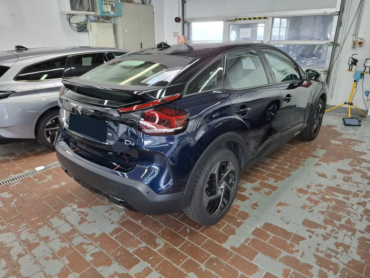 Vue 3/4 arrière droite d'une Citroën C4 2024 Bleu Eclipse avec toit noir et jantes alliage noires.