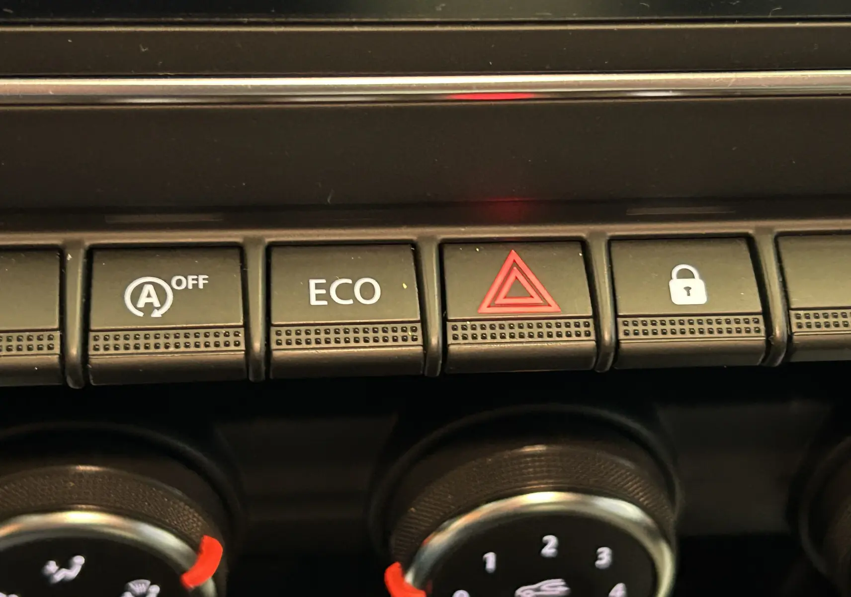 Gros plan sur les boutons de commande du tableau de bord de la Renault Clio V, avec fonction ECO et alerte triangle rouge.