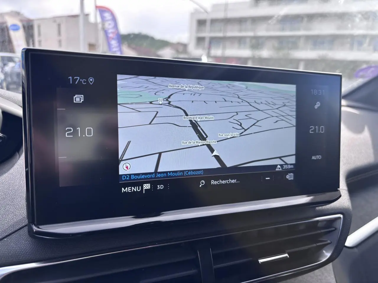 Écran tactile du système de navigation du Peugeot 5008 blanc, vue intérieure centrée sur la console centrale.