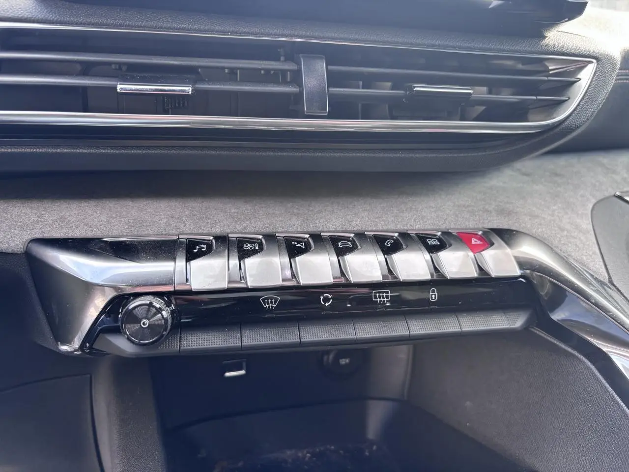 Détail de la console centrale avec les boutons métalliques et la grille d'aération du Peugeot 5008 blanc, version GT 2022.