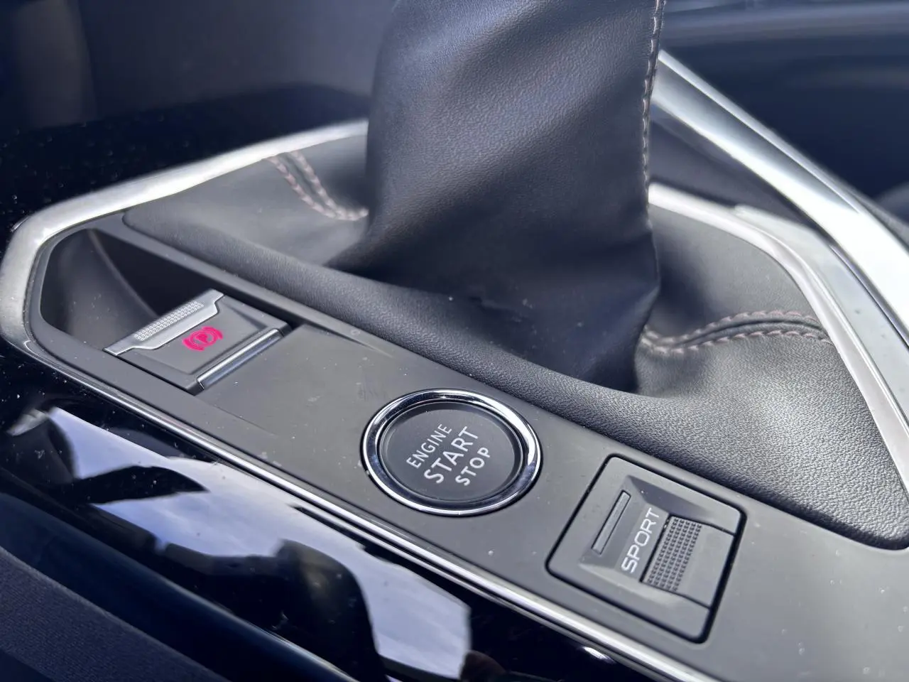 Gros plan sur la console centrale du Peugeot 5008 blanc 2022, avec bouton start/stop et commande mode sport.