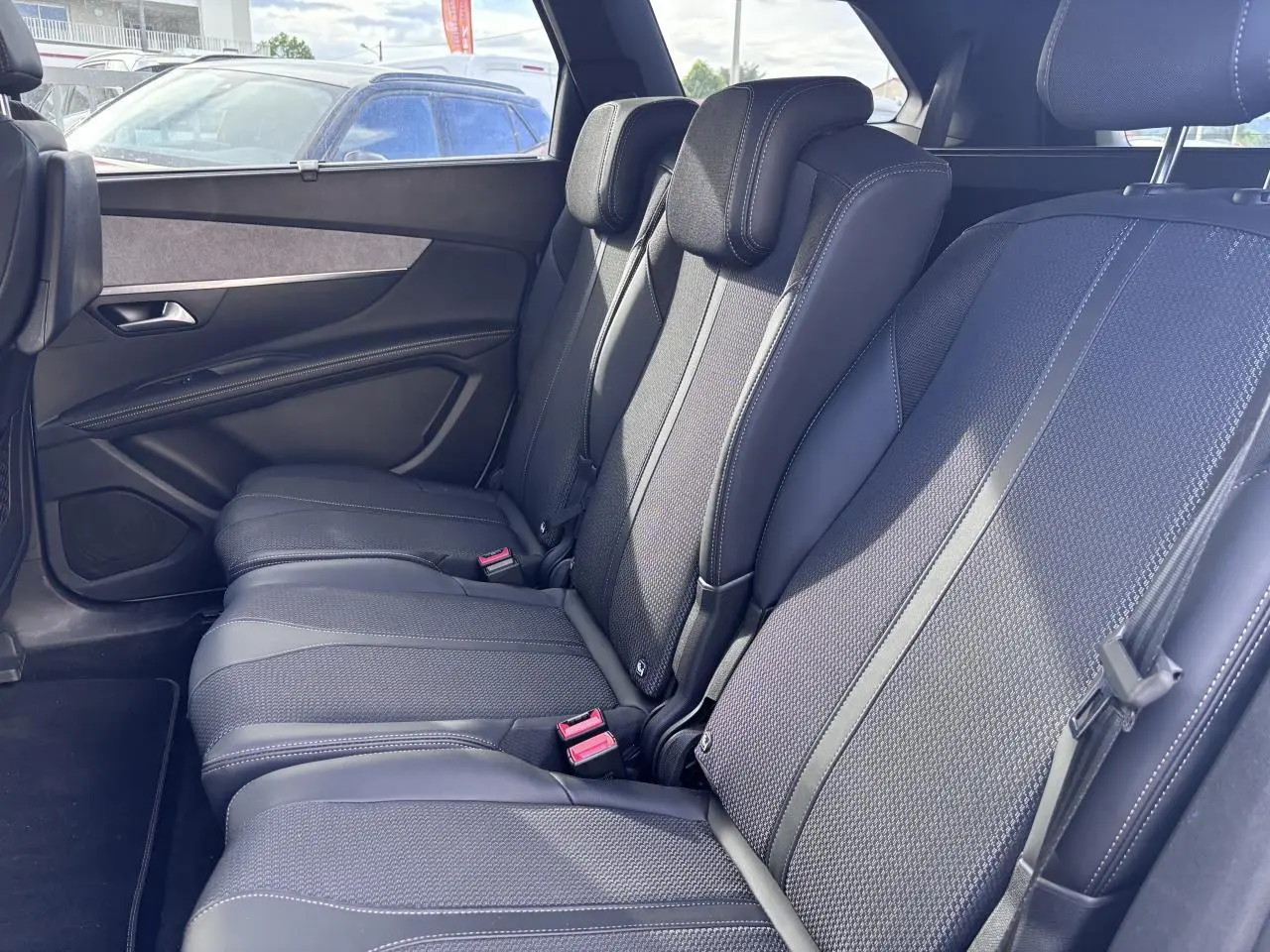 Vue latérale droite sur les sièges arrière noirs en tissu et cuir du Peugeot 5008 blanc, version GT 2022.