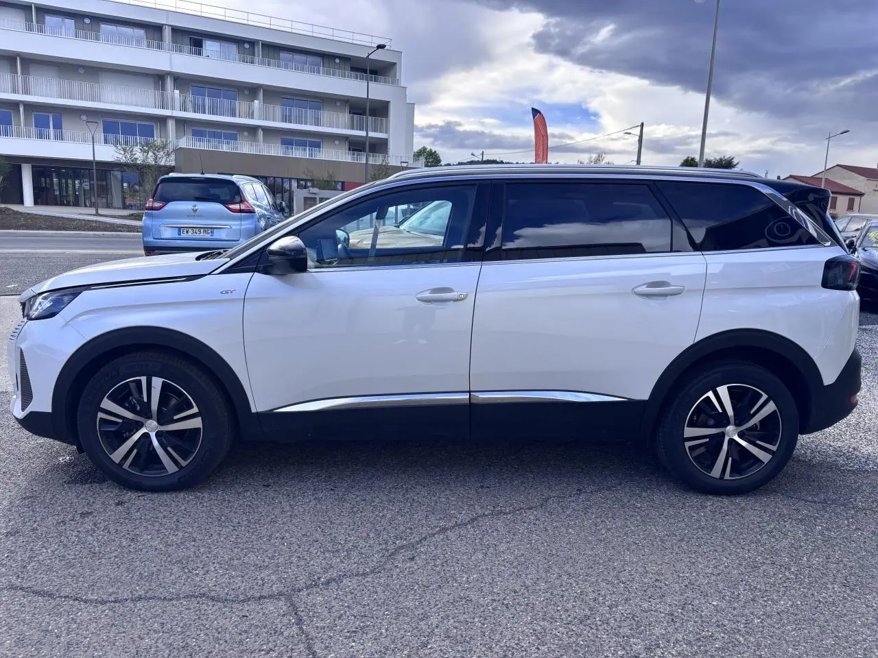 Vue de profil côté gauche d’un Peugeot 5008 blanc 2022 avec jantes alliage et toit noir contrasté.