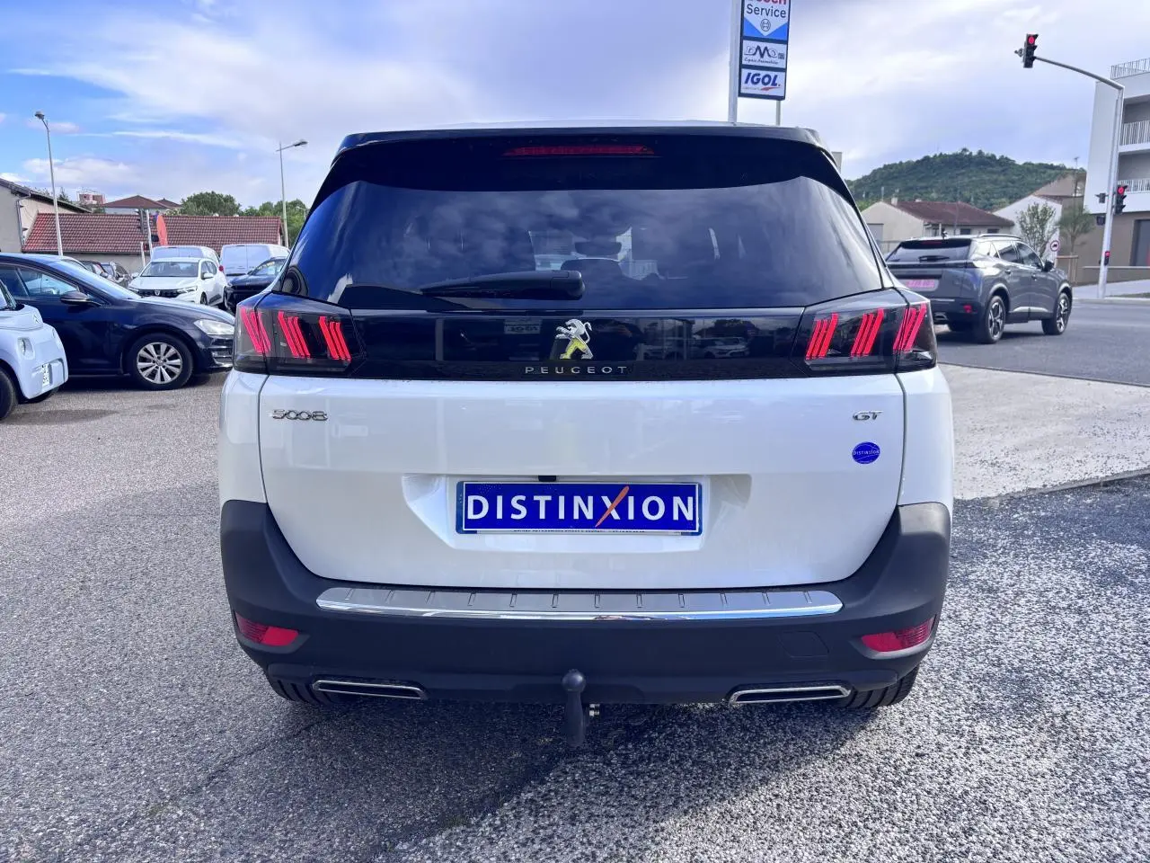 Vue arrière d'un Peugeot 5008 blanc GT 2022 avec feux arrière distinctifs et attelage visible.