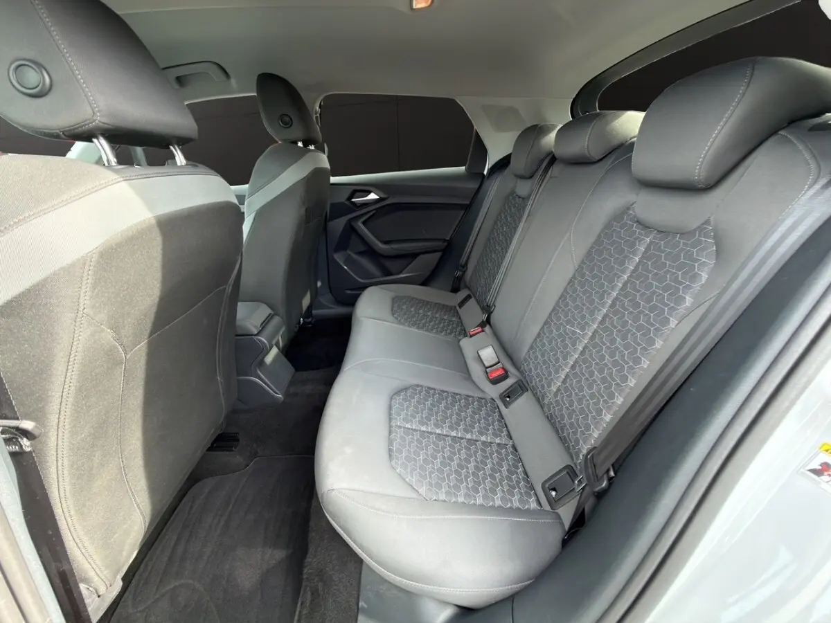 Vue intérieure côté droit des sièges arrière gris avec motifs géométriques d'une Audi A1 Sportback blanche 2025.