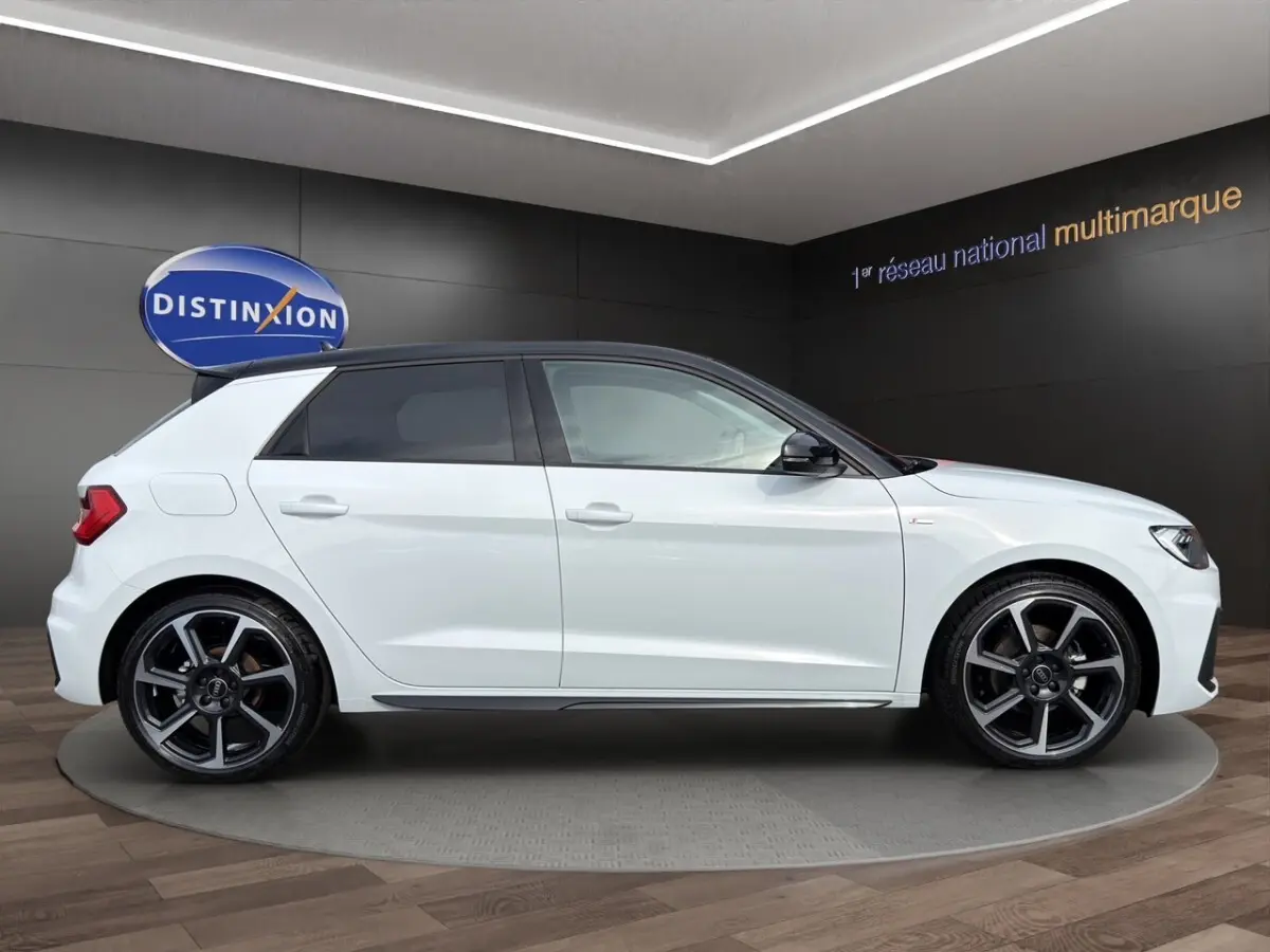 Audi A1 Sportback blanc vue de profil côté gauche, avec toit noir et jantes alliage distinctives.