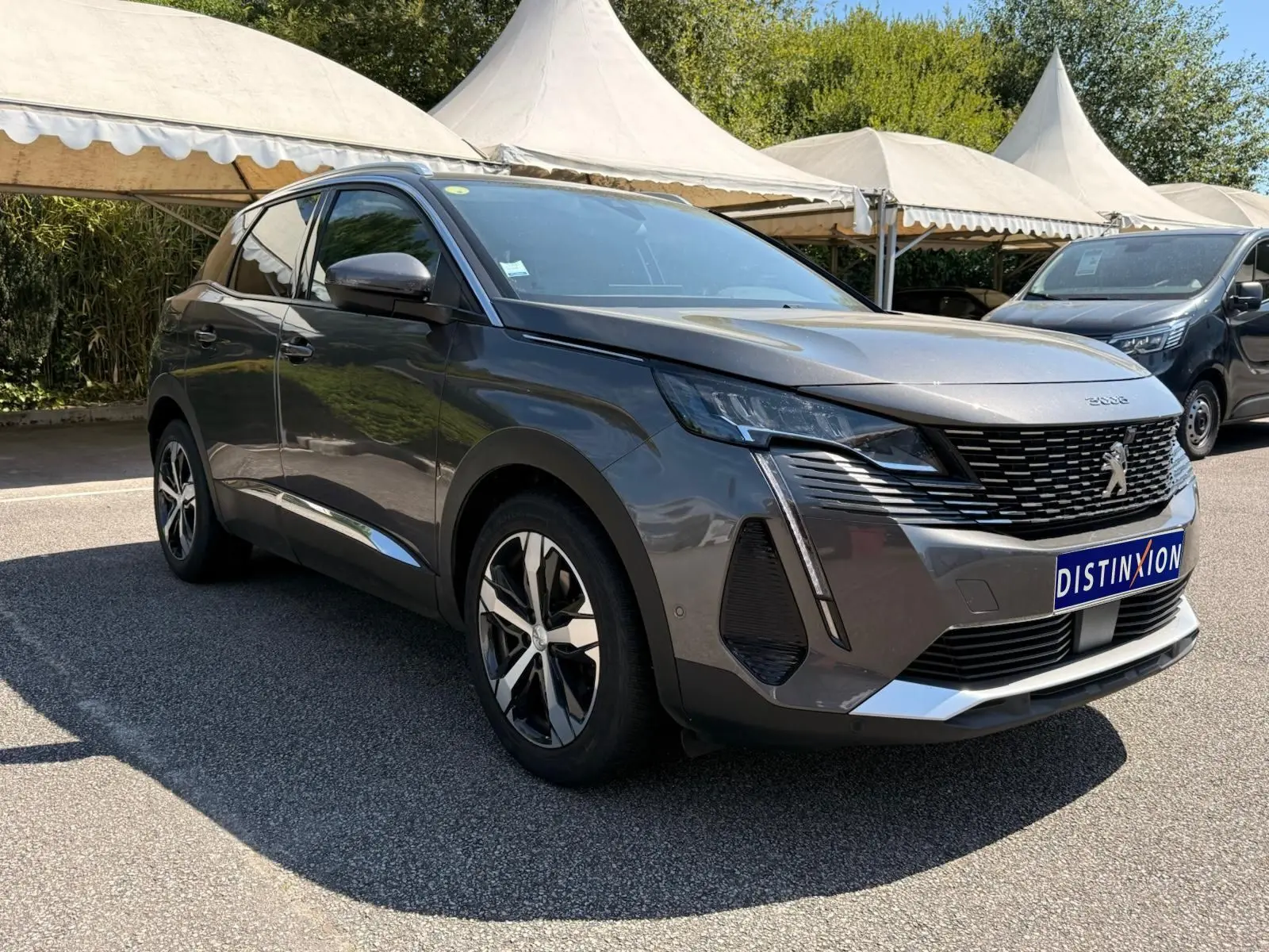 Peugeot 3008 gris platinium en 3/4 avant droit, avec calandre noire et jantes alliage bicolores.
