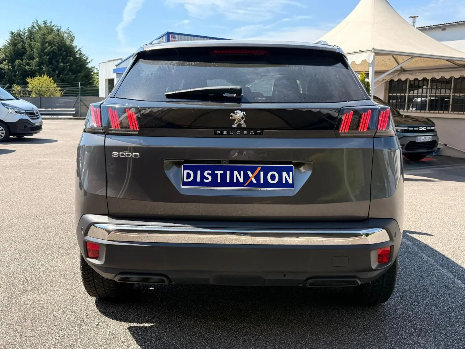 Vue arrière d’un Peugeot 3008 gris platinium 2021 avec feux arrière à griffes rouges et bandeau noir brillant.