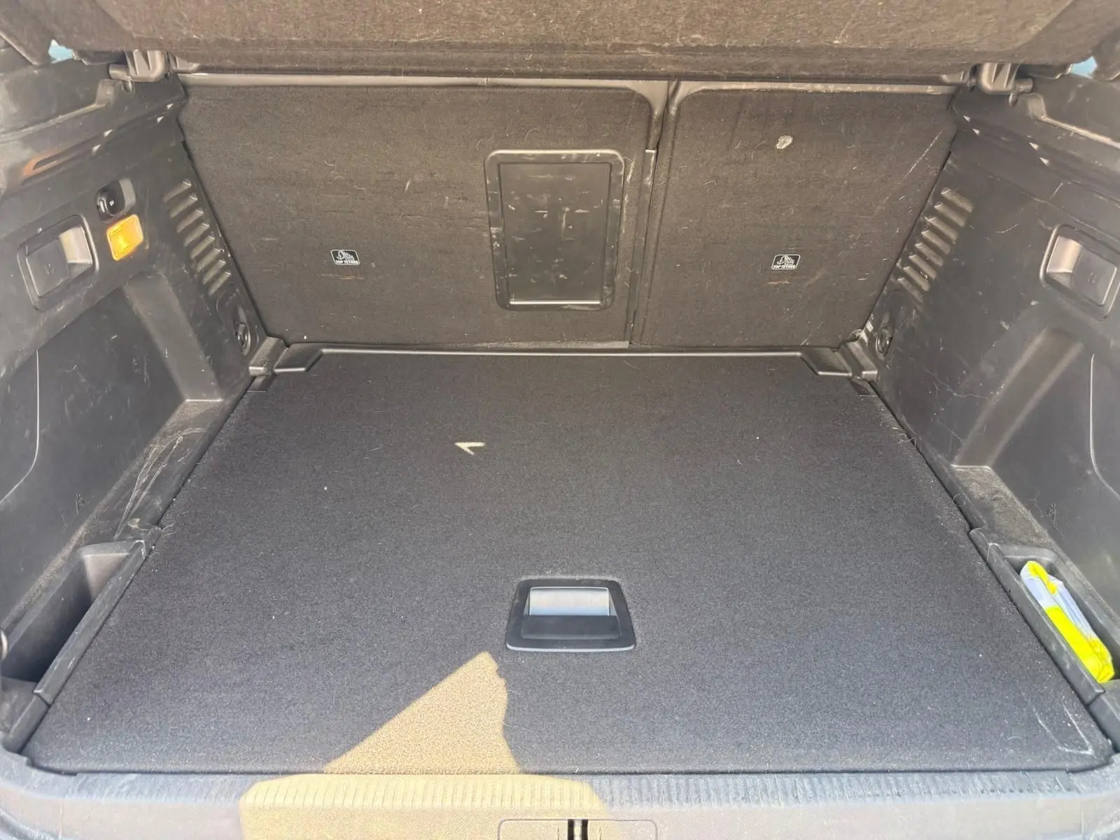 Coffre ouvert du Peugeot 3008 gris platinium, vue intérieure montrant le plancher plat et les rangements latéraux.