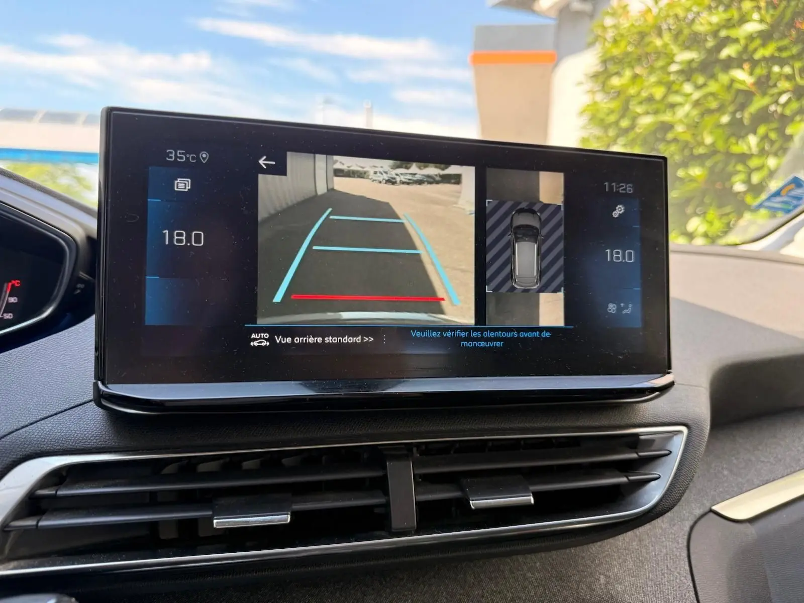 Écran tactile intérieur du Peugeot 3008 2021 montrant la caméra de recul et l'affichage de la température à 18°C.