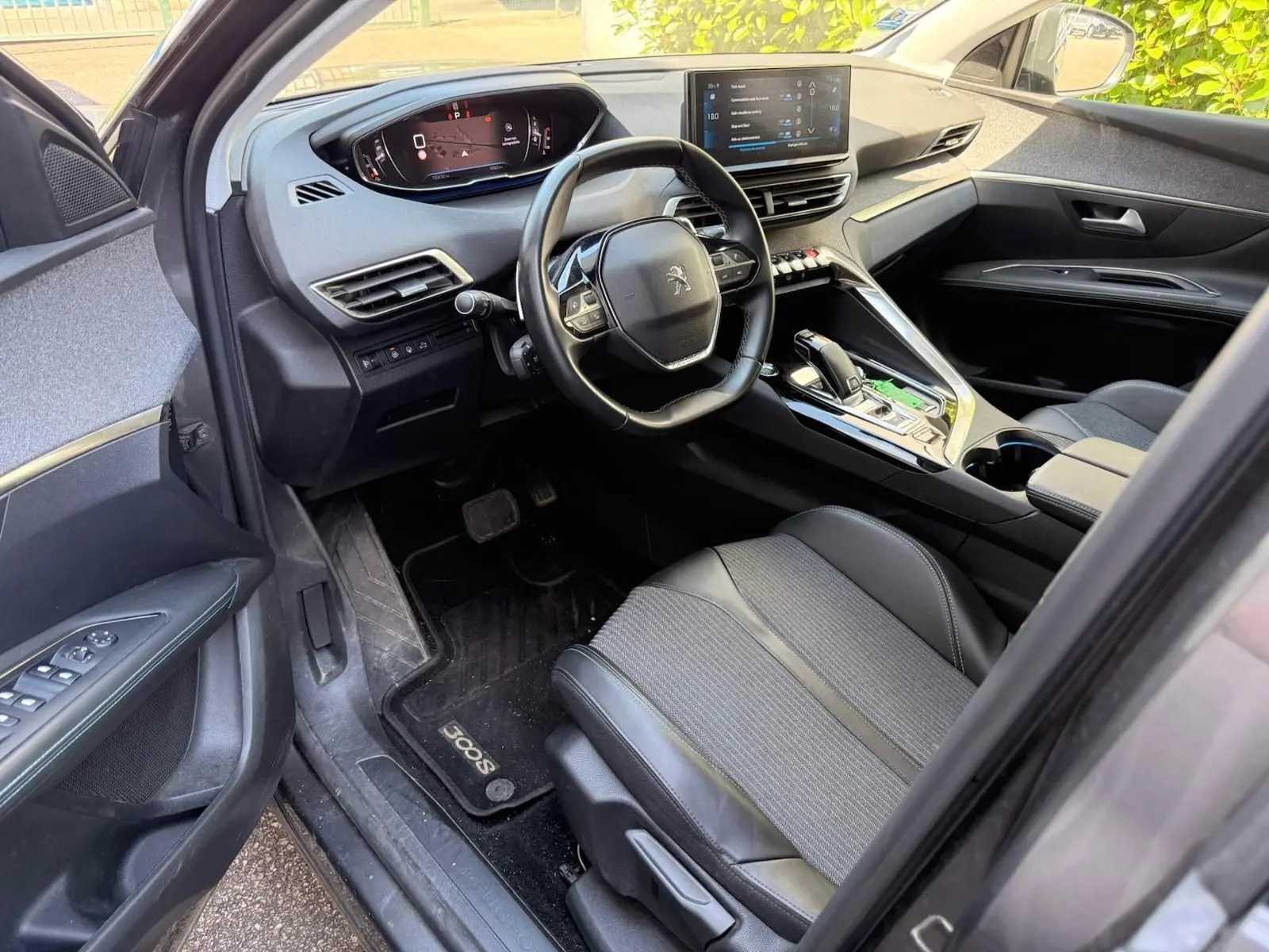 Vue intérieure côté conducteur du Peugeot 3008 gris platinium, mettant en valeur le tableau de bord numérique et la console centrale moderne.
