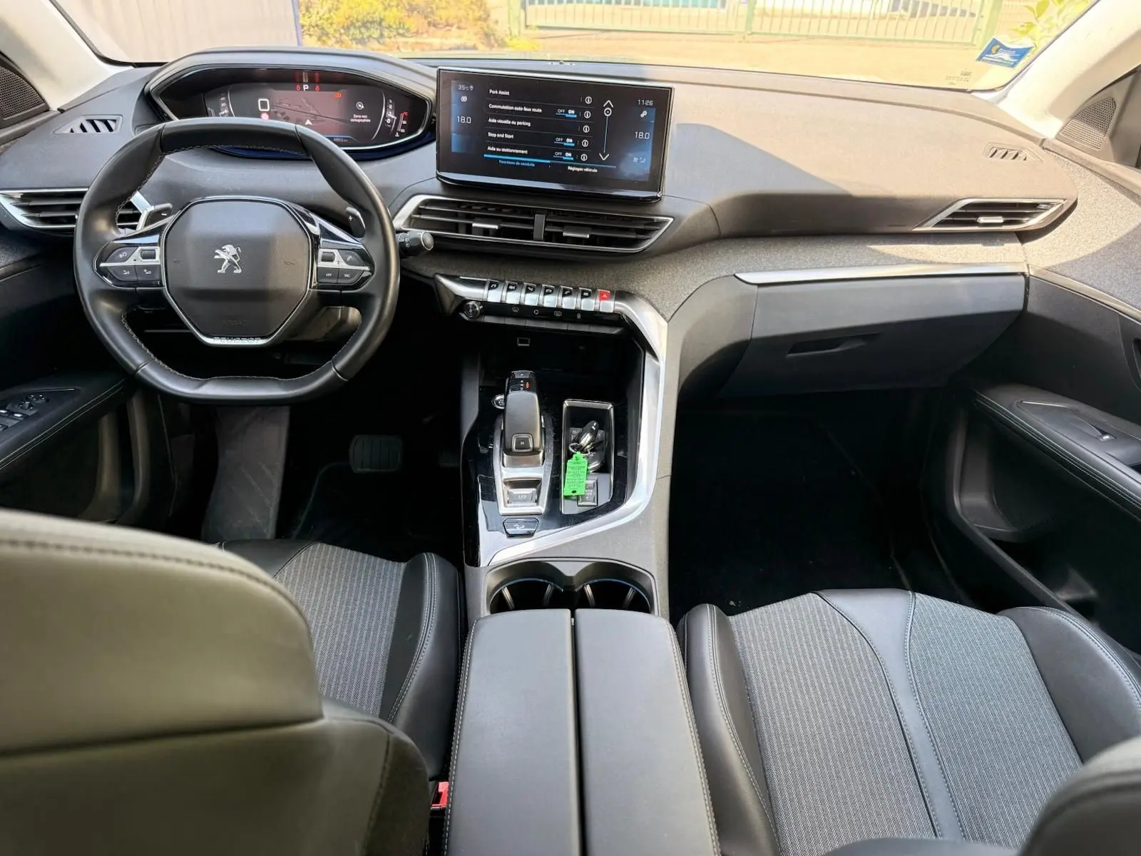 Vue intérieure avant du Peugeot 3008 2021, tableau de bord moderne avec écran tactile et volant compact noir.