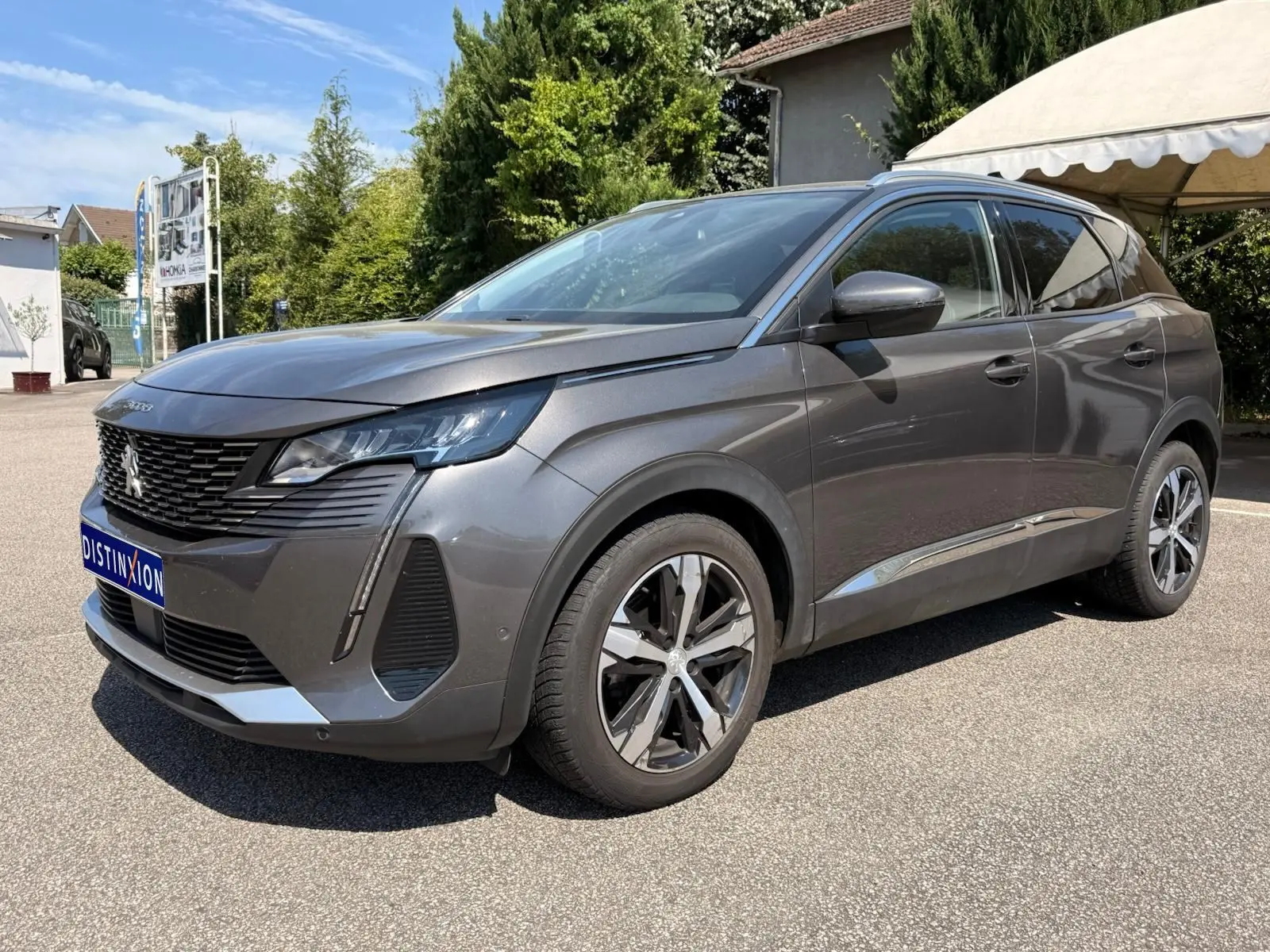Peugeot 3008 gris platinium vue 3/4 avant droit, avec jantes alliage bicolores et calandre noire distinctive.