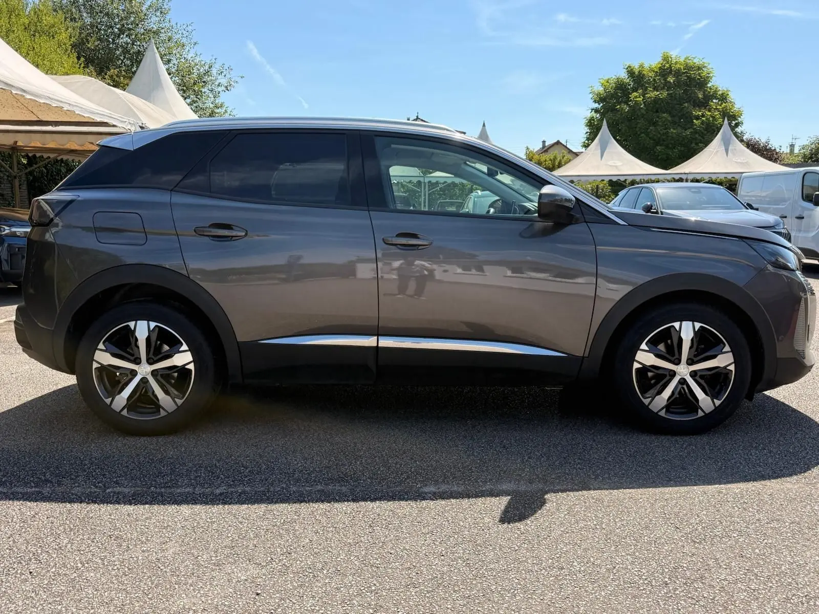 Peugeot 3008 gris platinium vue de profil côté gauche, soulignant ses jantes bicolores et lignes épurées.