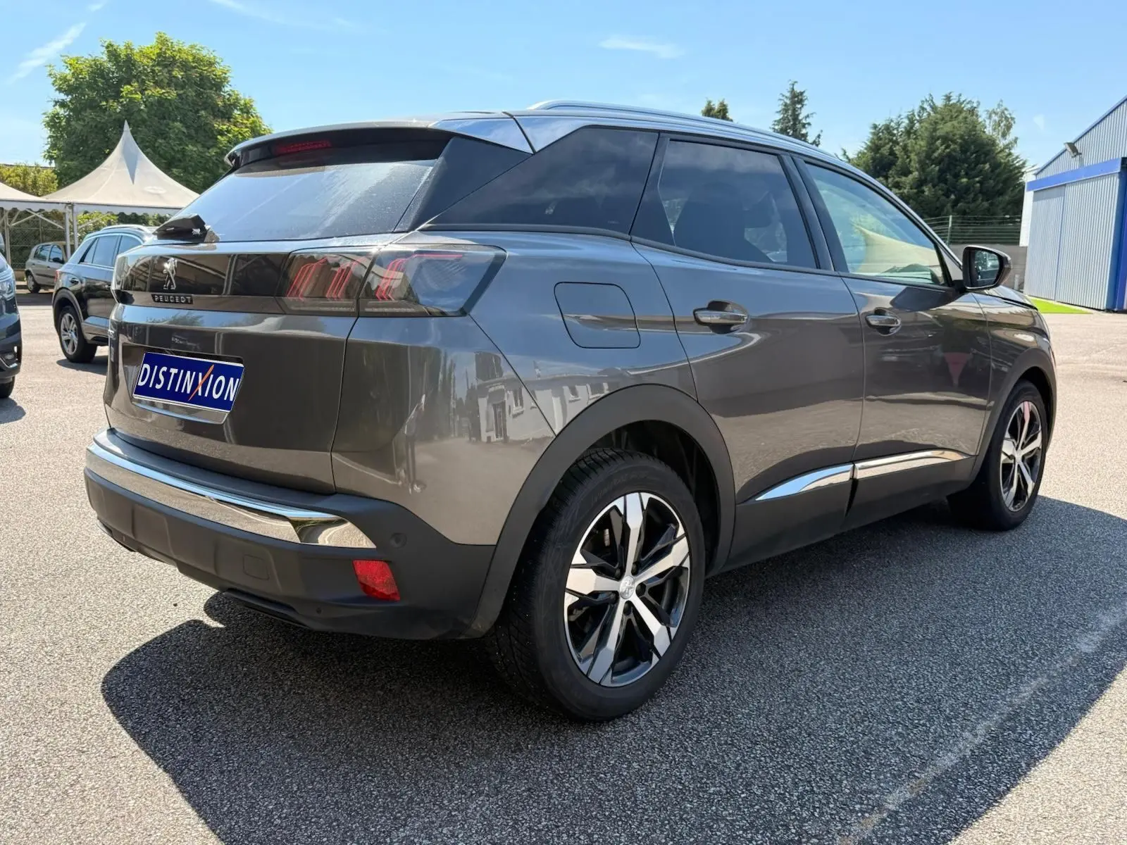 Peugeot 3008 gris platinium en 3/4 arrière droit, avec jantes bi-ton et feux arrière LED caractéristiques.