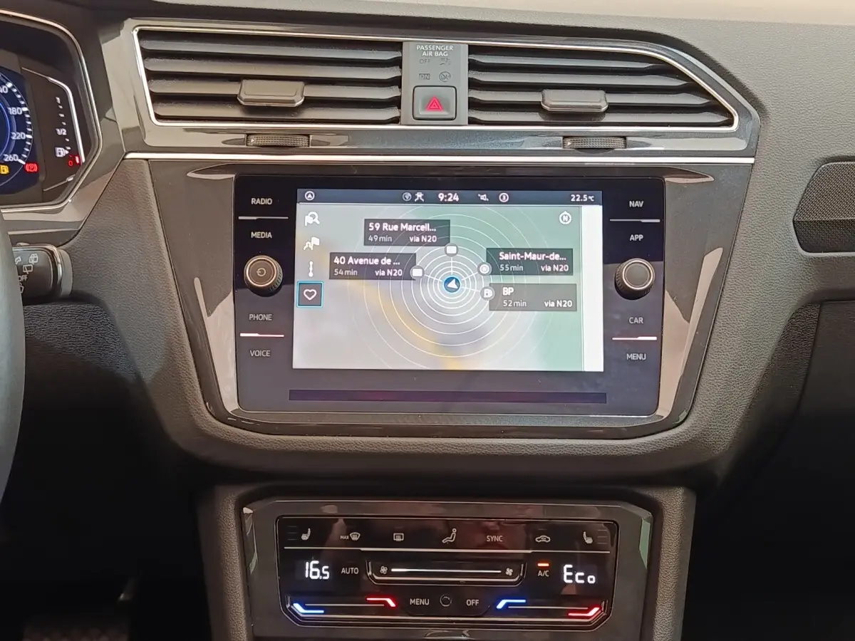 Vue rapprochée de la console centrale du Volkswagen Tiguan 2022, écran tactile de navigation et commandes climatisation.