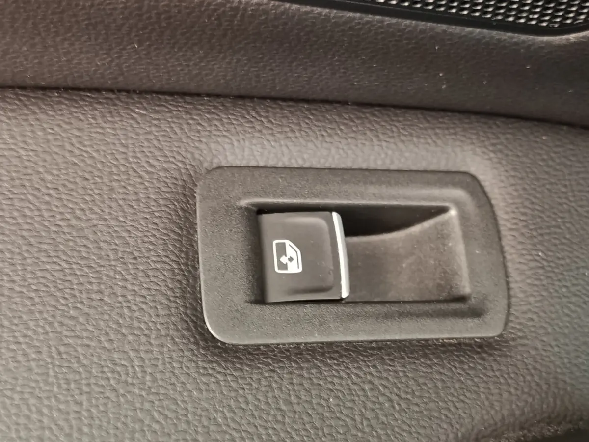 Gros plan sur bouton de commande électrique de vitre arrière dans l’habitacle noir du Volkswagen Tiguan 1.4 eHybrid 2022.