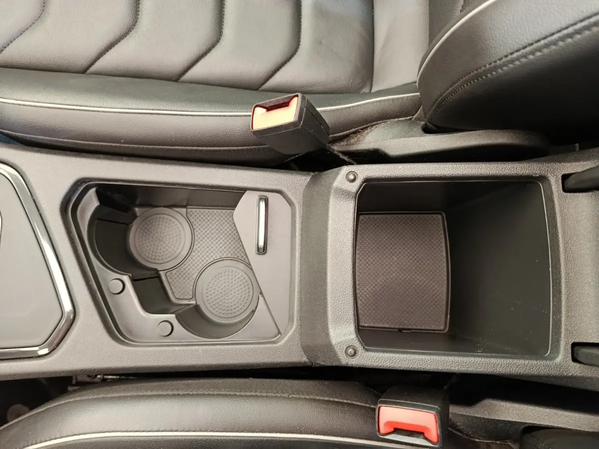 Vue plongeante sur le rangement central noir et porte-gobelets du Volkswagen Tiguan 1.4 eHybrid 2022.