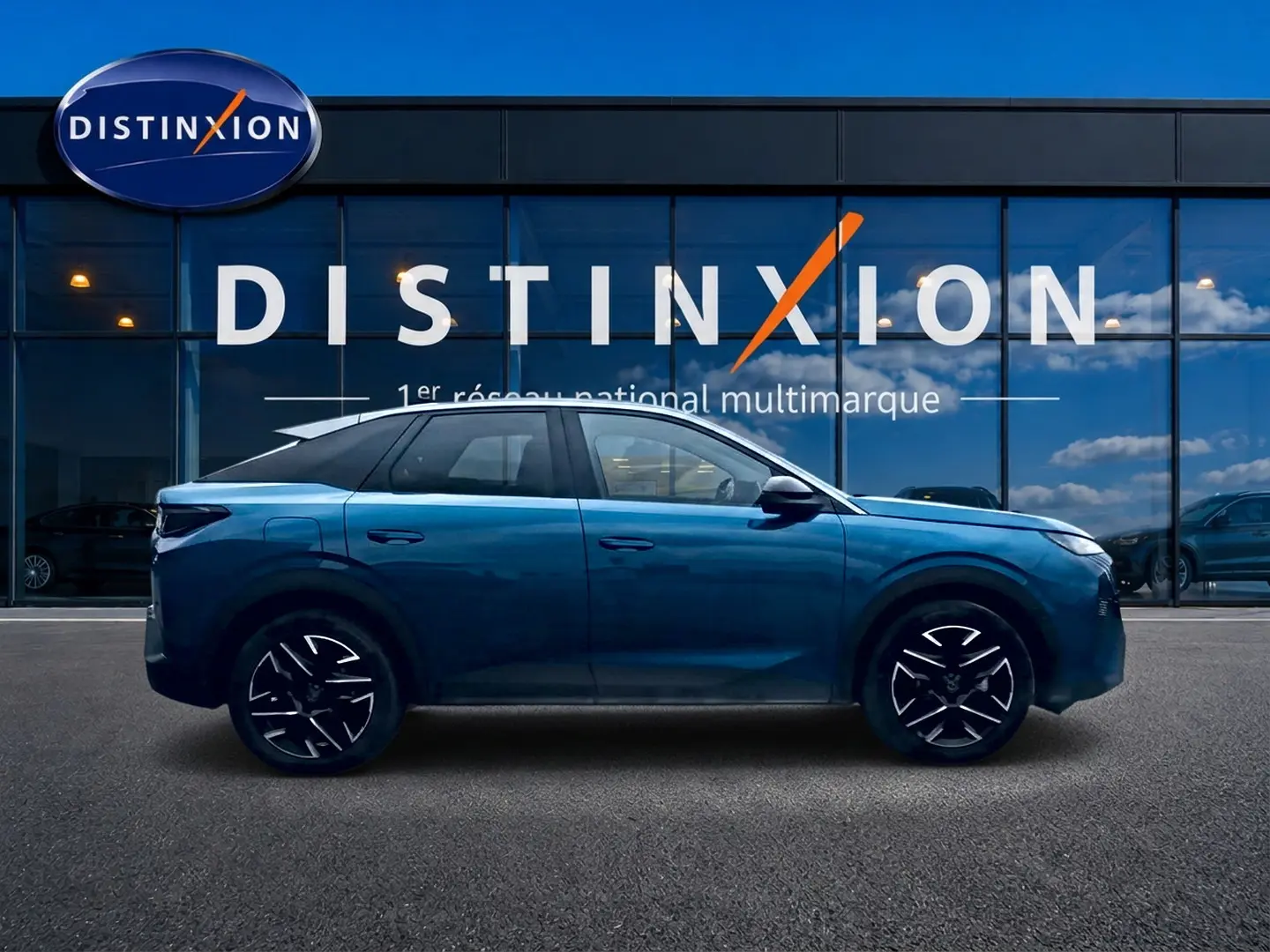 Profil côté gauche du Peugeot 3008 bleu 2025 avec jantes alu et toit noir devant une vitrine Distinxion.