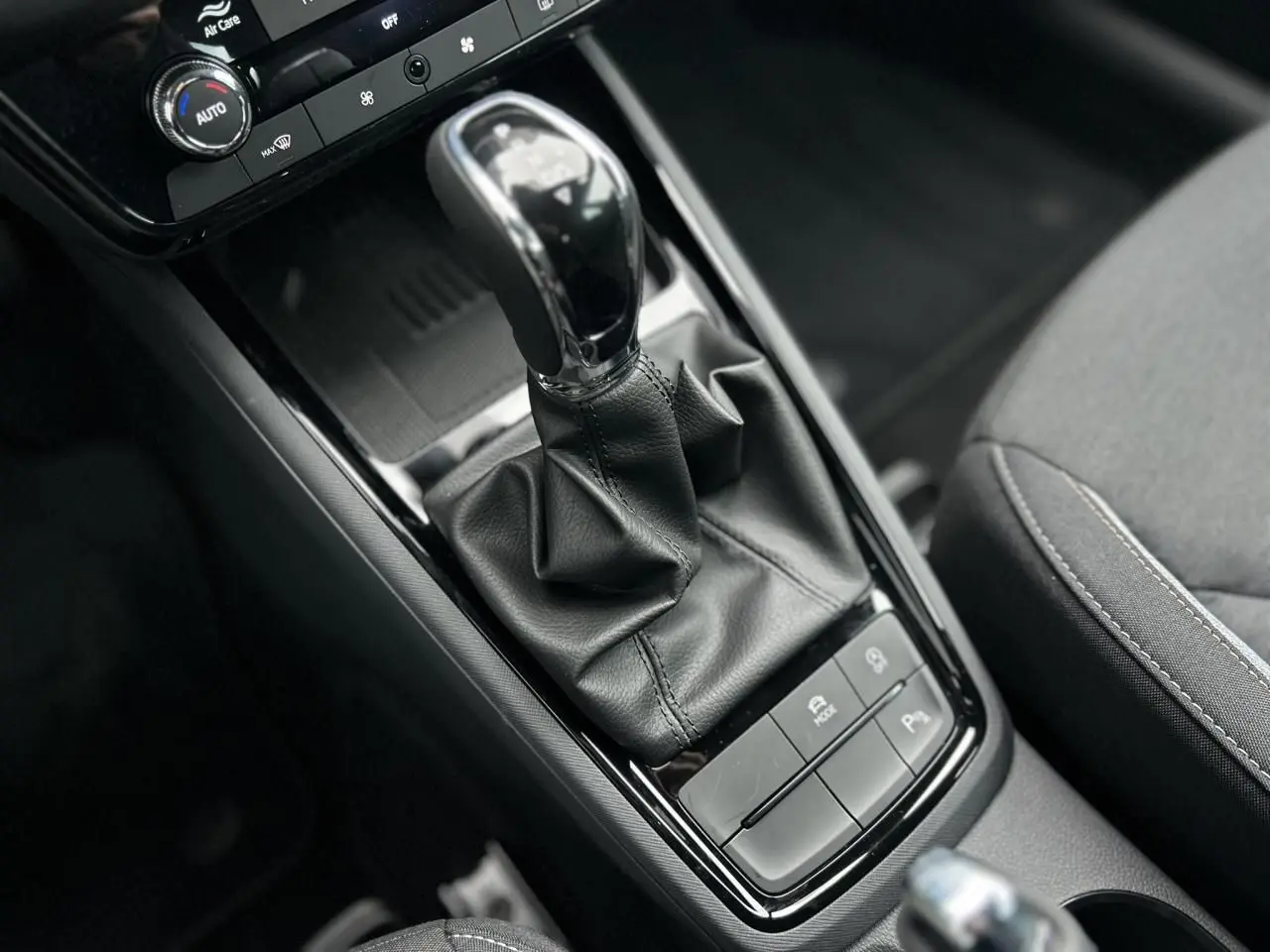 Gros plan sur la console centrale du Skoda Kamiq noir Magic, mettant en valeur le levier de vitesse automatique et les commandes de confort.