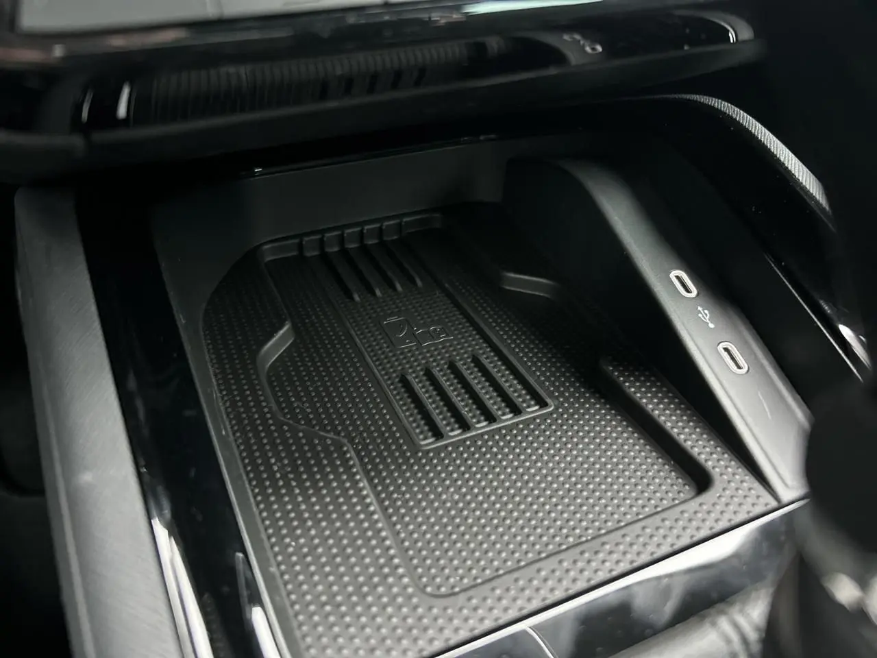 Vue rapprochée de la console centrale noire du Skoda Kamiq avec chargeur induction et ports USB-C visibles.