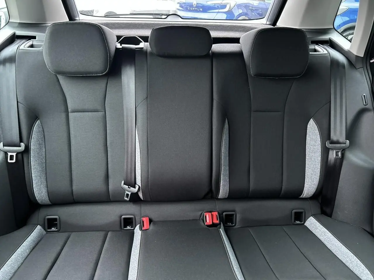 Vue arrière intérieure montrant la banquette arrière noire avec surpiqûres grises du Skoda Kamiq 2025.