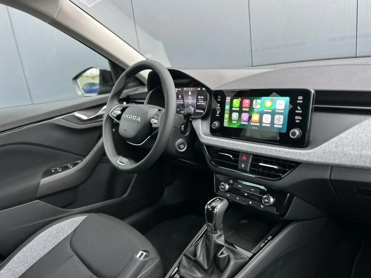 Intérieur avant gauche du Skoda Kamiq 2025, volant multifonctions noir et écran tactile Apple CarPlay visible.