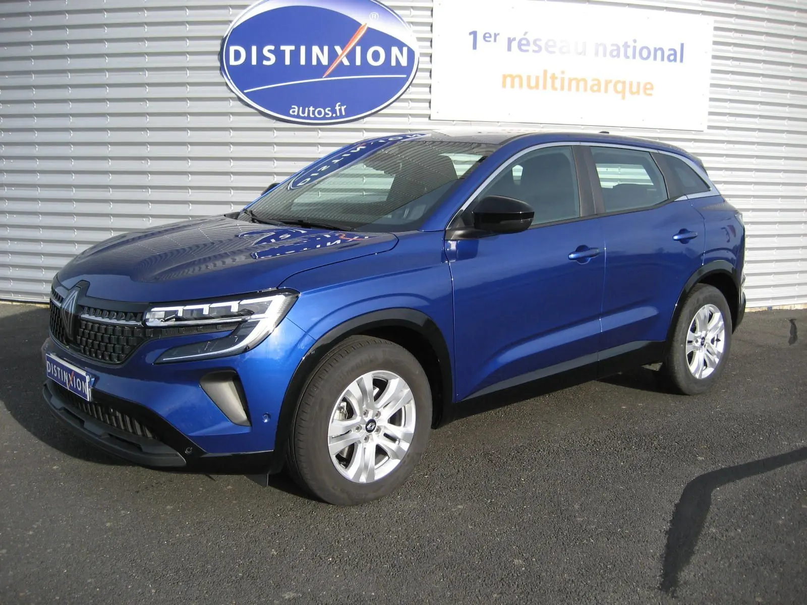 Renault Austral Evolution E-Tech bleu Iron en vue 3/4 avant droit, avec calandre noire et jantes argentées.