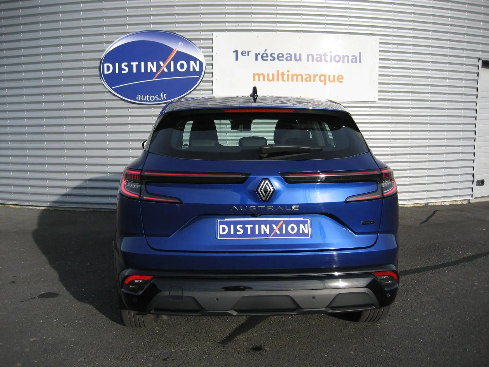 Vue arrière d'un Renault Austral bleu Iron 2025 avec feux LED horizontaux et logo distinctif au centre.