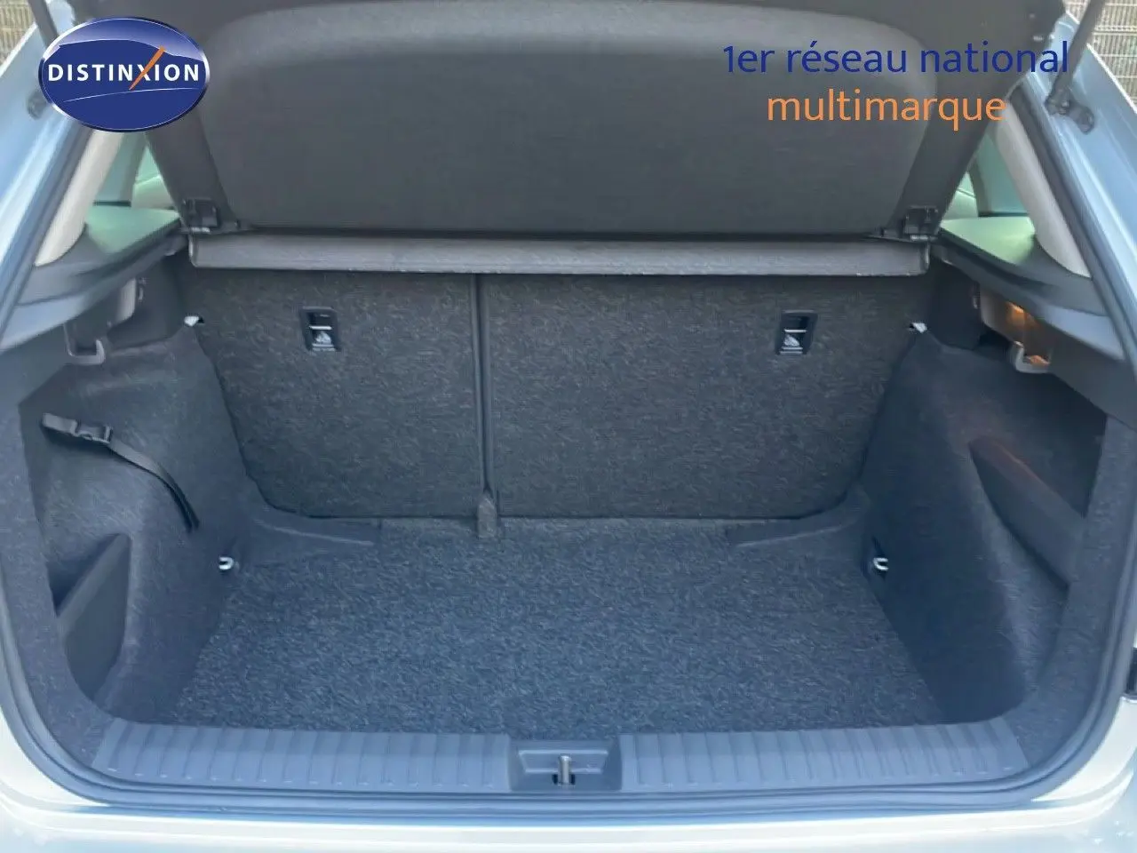 Coffre ouvert vu de l'arrière d'un Skoda Kamiq gris argent métal, montrant l'espace de chargement vide.